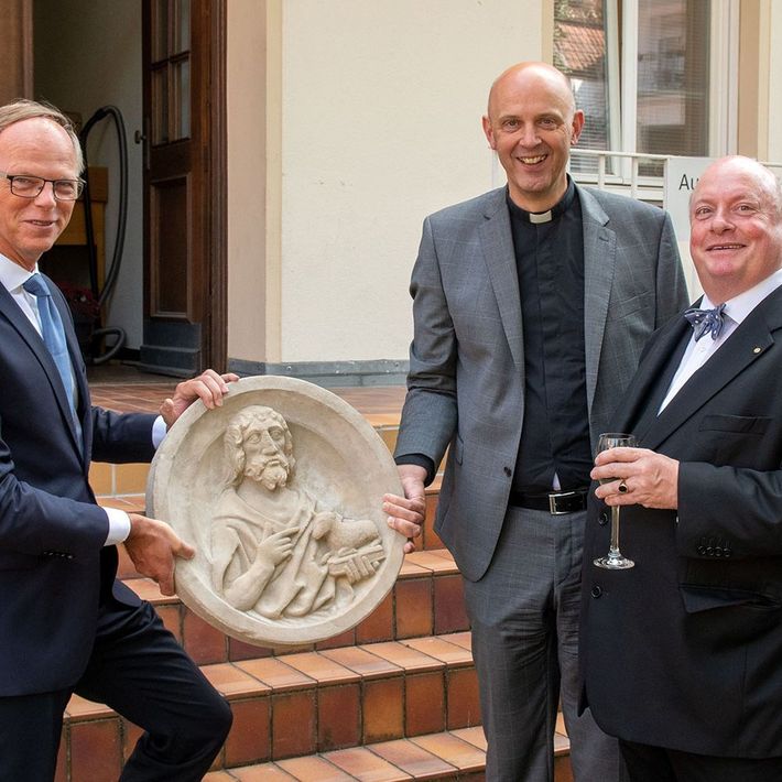 Generalvikar Dr. Klaus Winterkamp und Dompropst Kurt Schulte (von links) überreichten dem scheidenden Diözesankonservator Dr. Udo Grote einen Rippenstein aus dem St.-Paulus-Dom. 