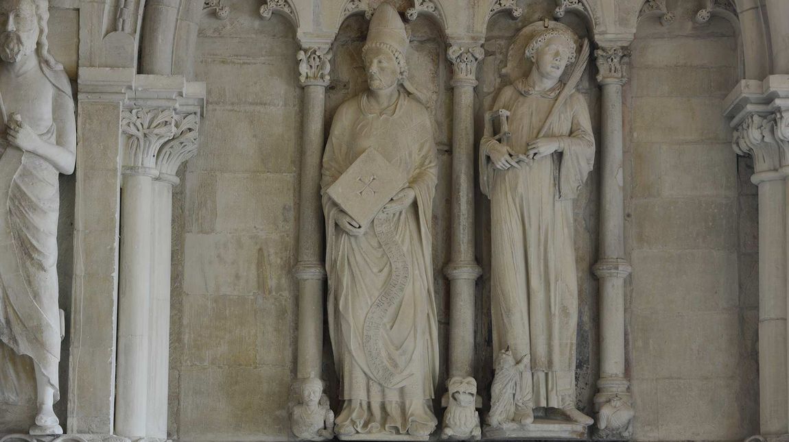Statue des Fürstbischofs Dietrich von Isenburg im Domparadies; er trägt den Grundstein (1225) in seinen Händen; rechts neben ihm der heilige Laurentius.
